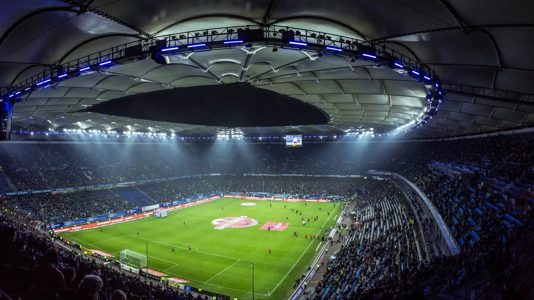 Estadio lotado de torcedores durante uma partida noturna